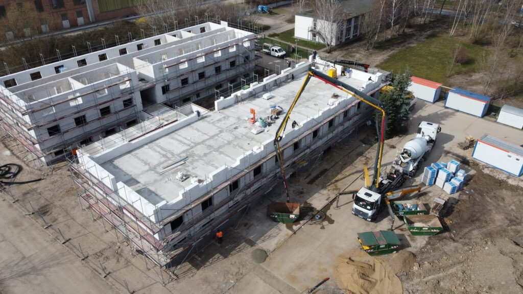 Luftaufnahme der GBPI-Baustelle in Köthen: Rohbau der Saisonunterkünfte mit Betonpumpe